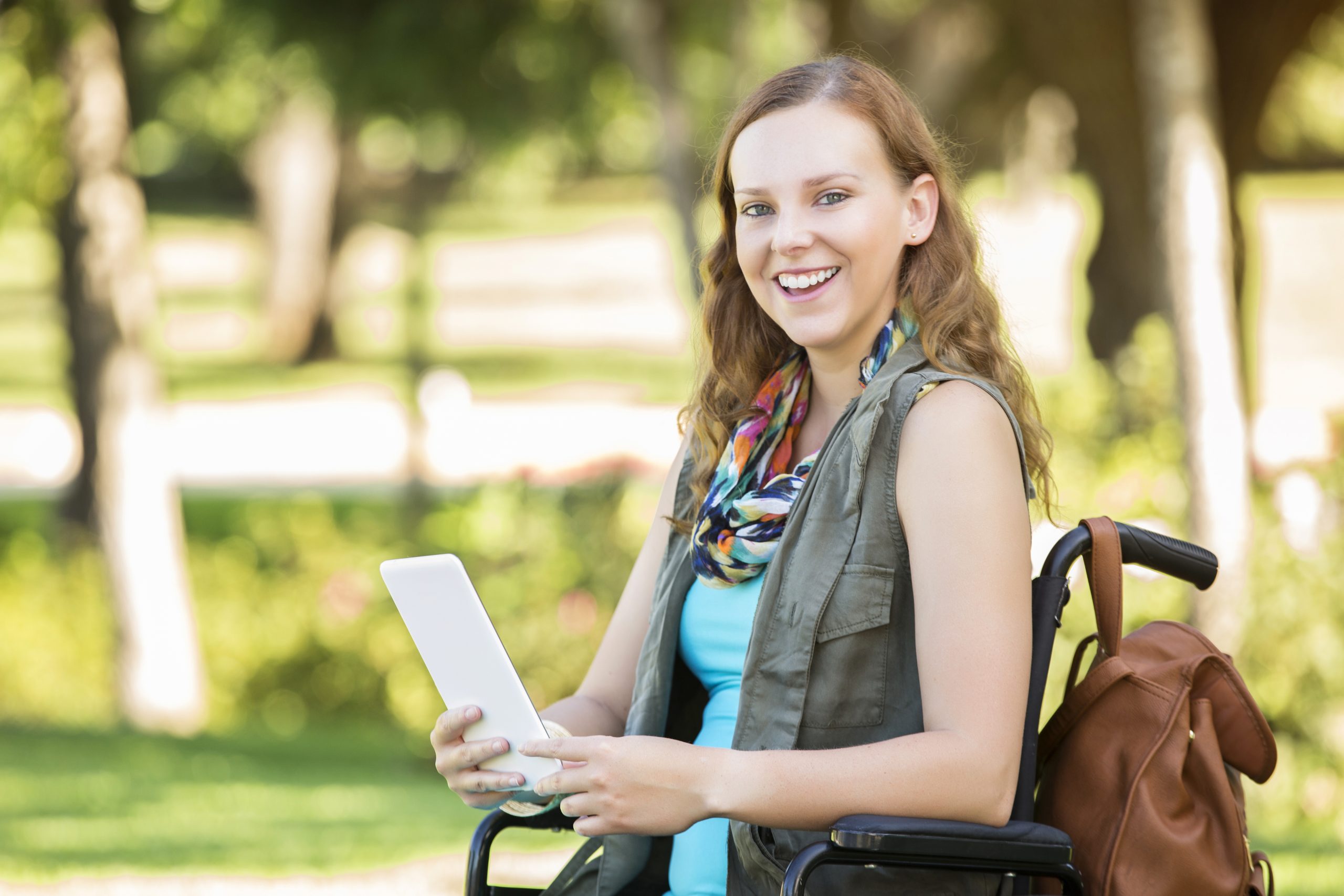 Smiling college girl in wheelchair on campus Smiling college girl in wheelchair on campus