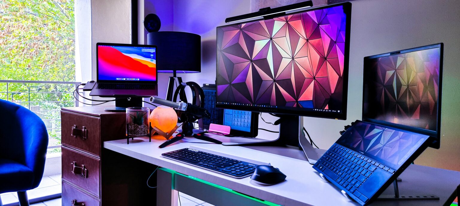 Several computer monitors on a white desk